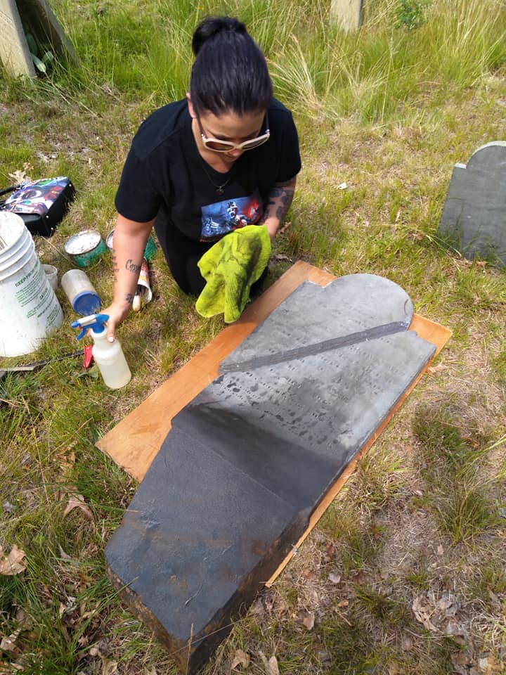 Johnelle Bergeron repairs a gravestone